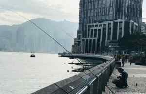 Ca mord ? Pêcheur sur la promenade de Tsim Sha Tsui - Hong-Kong